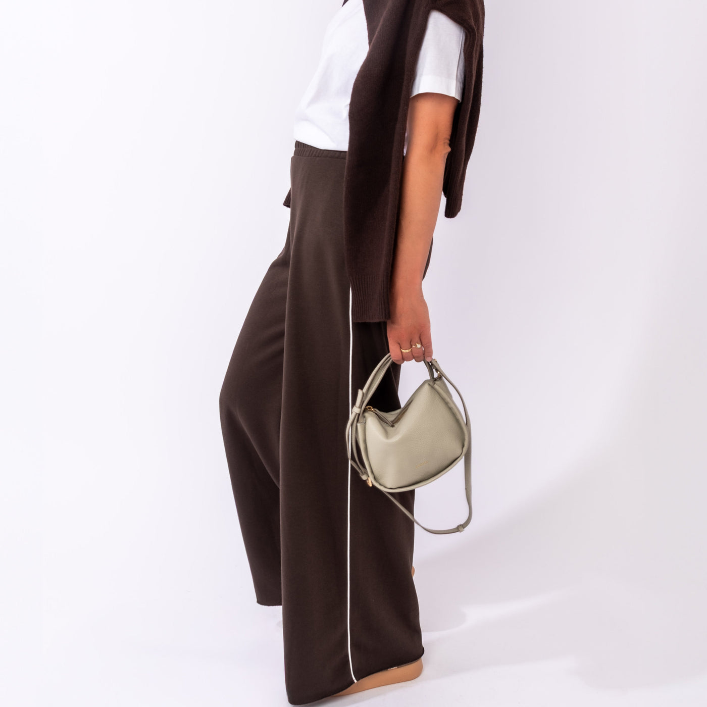 Model met verschillende zilveren clutches en crossbody tassen van LouLou Essentiels.